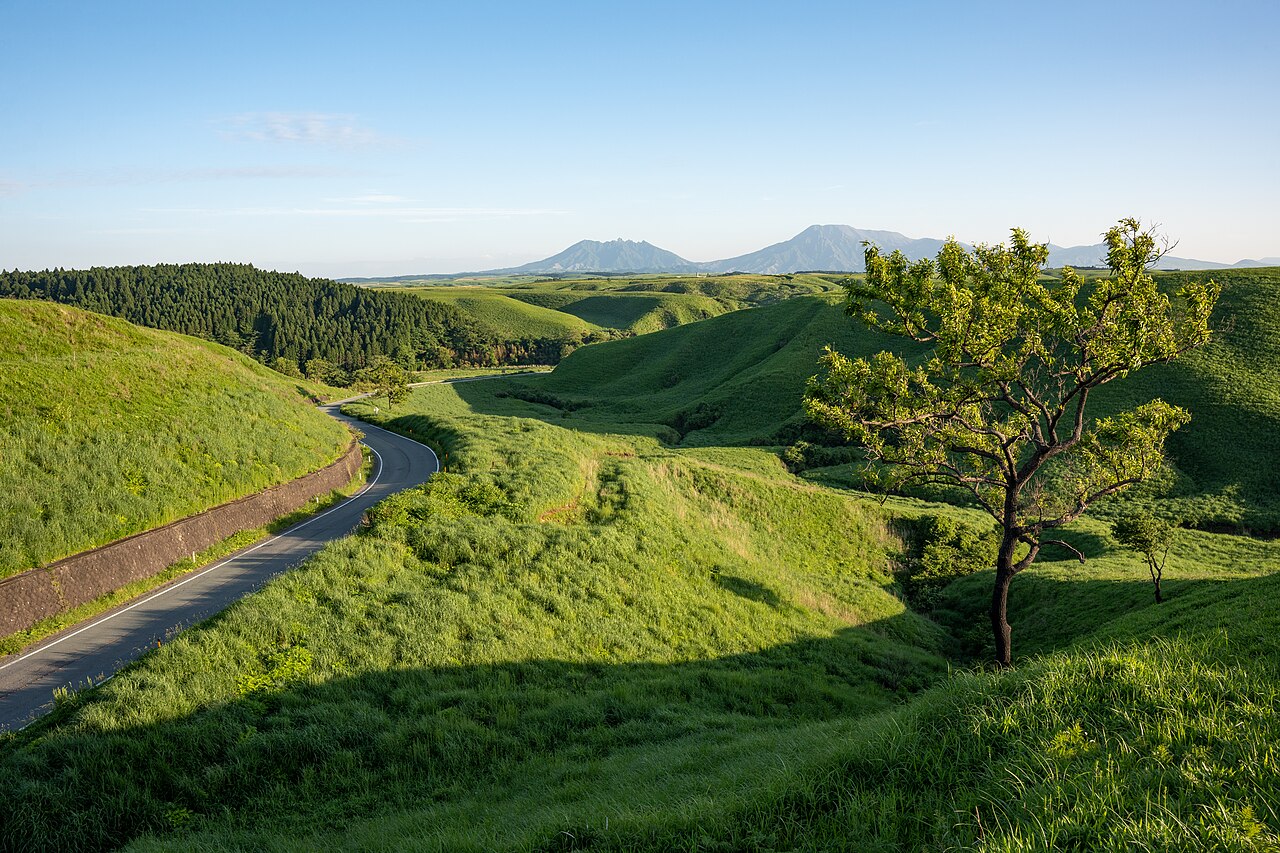 阿蘇の草原を抜ける道と、遠くに見える阿蘇五岳