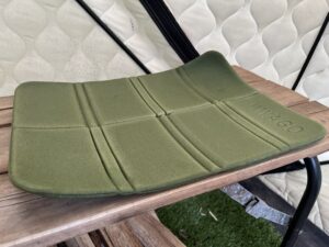 ミキタオサウナのテント内で使っている緑の折りたたみマット。木のベンチの上に置いても両端が反り返り、平らに戻らなくなっている